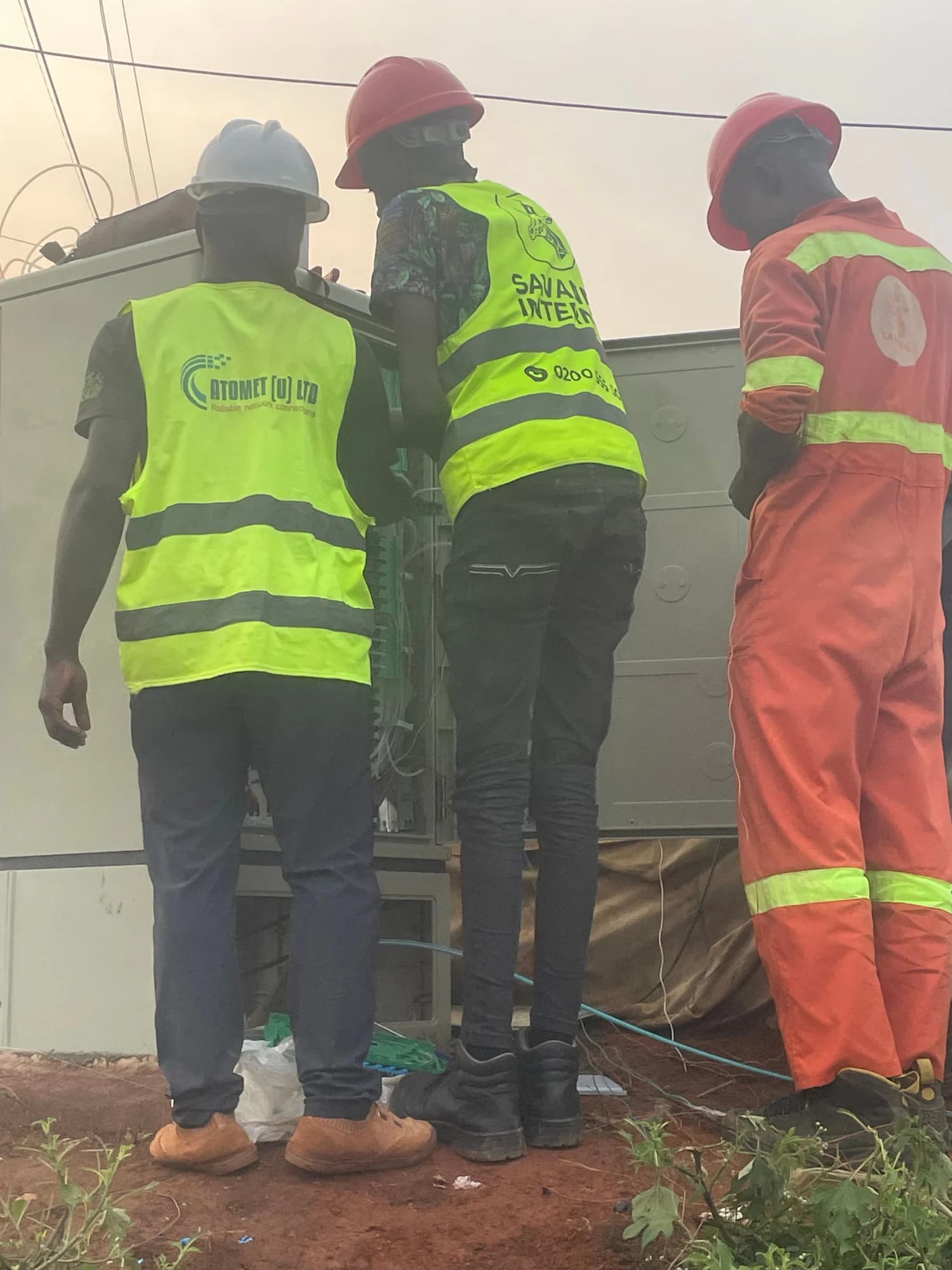 Atomet technicians in lime vests working at an open street cabinet