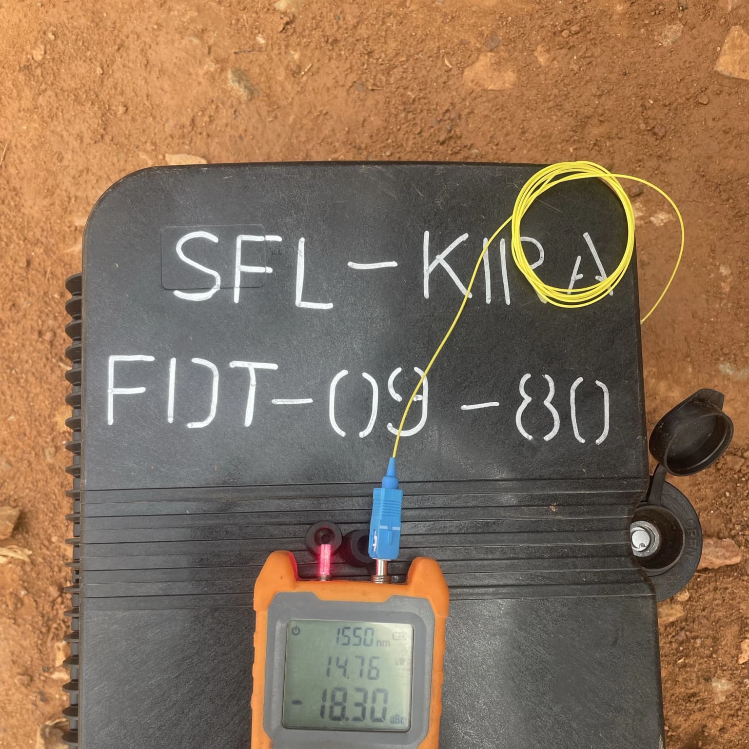 Optical power meter reading minus 18.30 dBm at 1550 nanometres, connected to a black termination box stencilled SFL-KIRA FDT-09-80