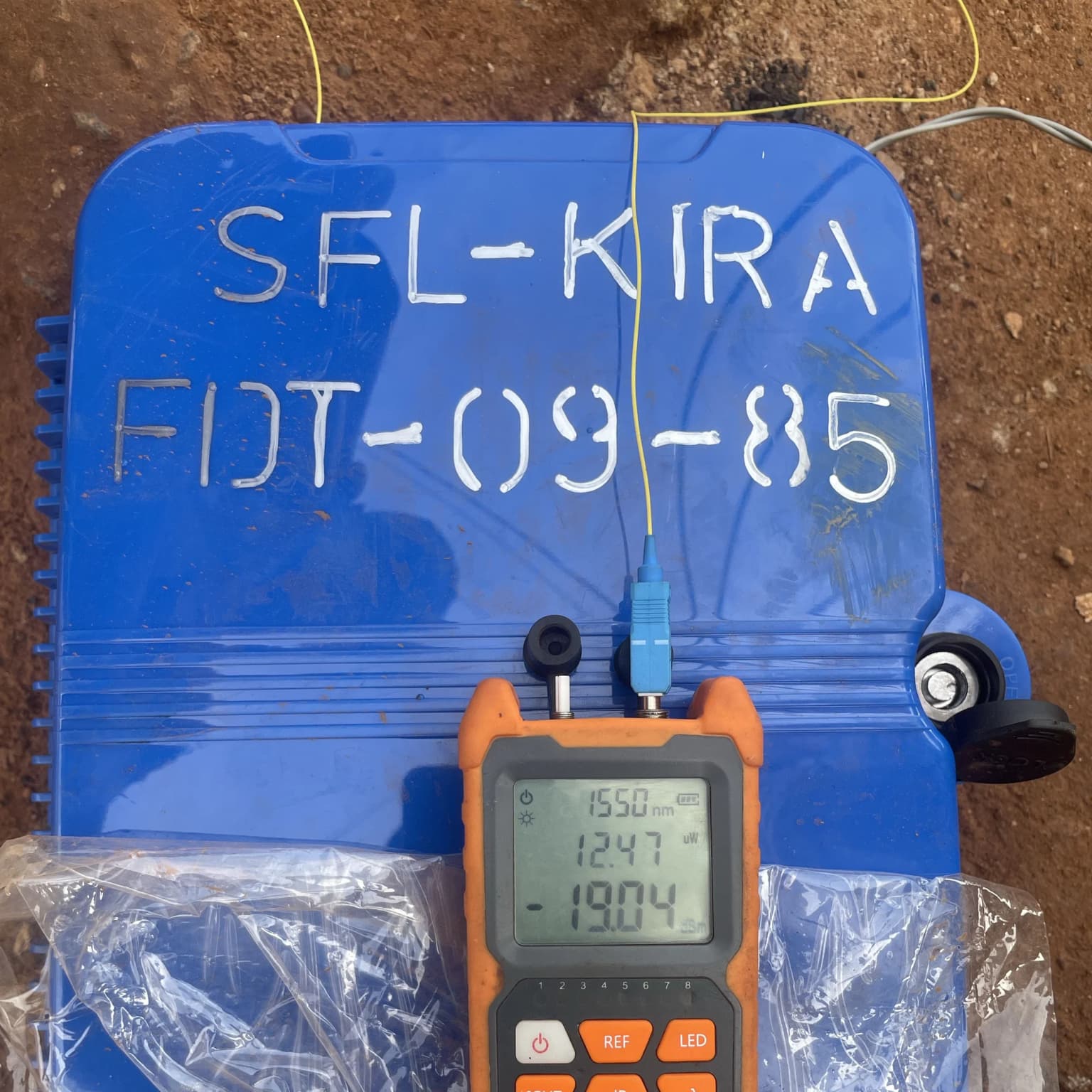 Optical power meter reading minus 19.04 dBm at 1550 nanometres on a blue termination box stencilled SFL-KIRA FDT-09-85